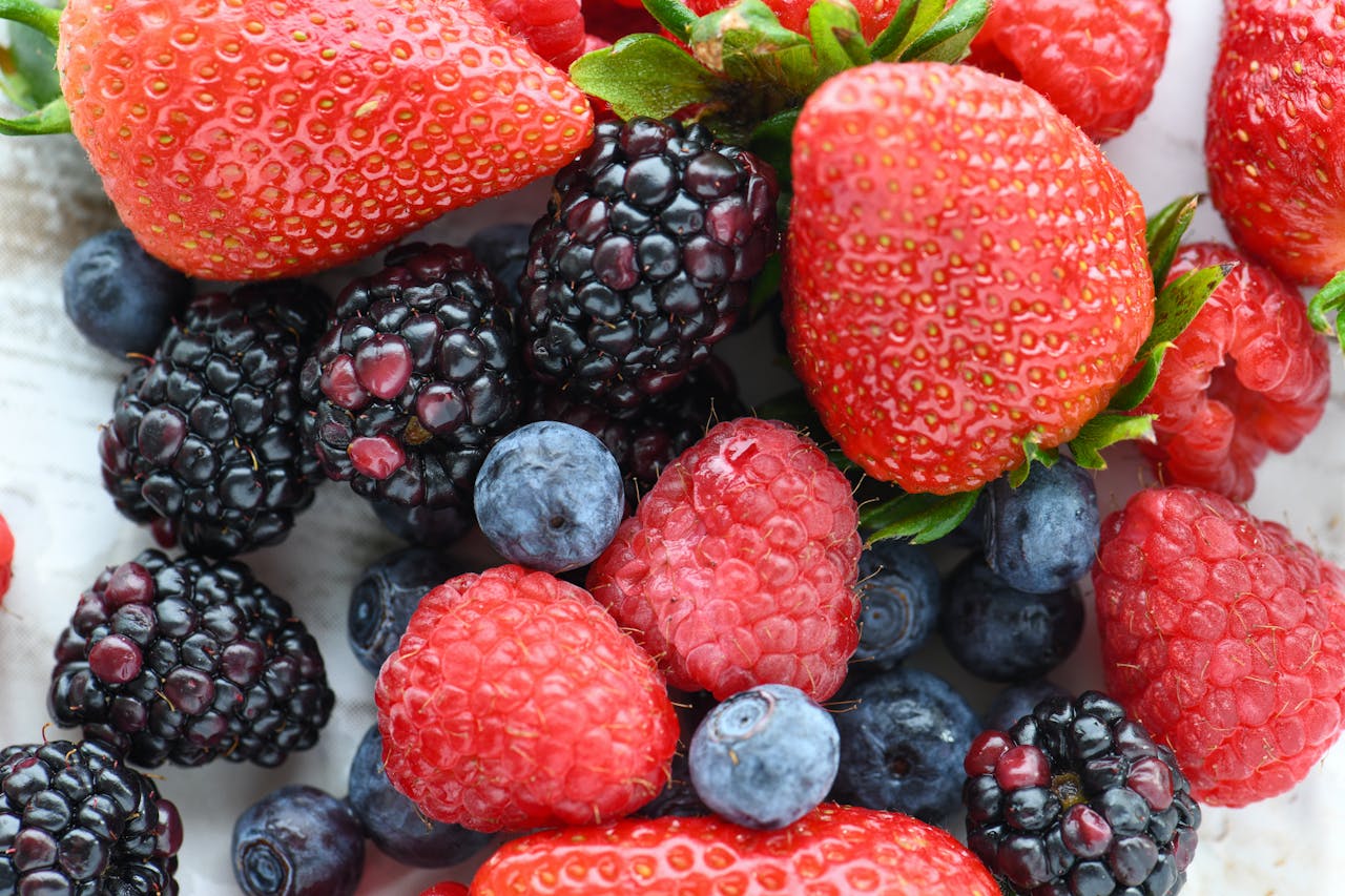A vibrant close-up of fresh strawberries, raspberries, blackberries, and blueberries.